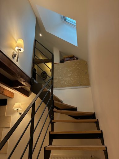 Escalier menant à un palier, avec lumière naturelle et décoration moderne.