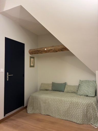 Espace de détente sous un escalier avec un canapé et des coussins colorés.